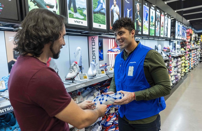 Imagen de un vendedor atendiendo a un cliente en una tienda Decathlon 