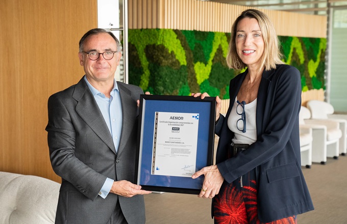 Imagen de Marta Aisa, directora de sostenibilidad de Santander España, y Javier Mejía, director de marketing estratégico y desarrollo de negocio de Aenor, mostrando la Certificación Compromiso con la Accesibilidad 360º, obtenida por la entidad financiera.