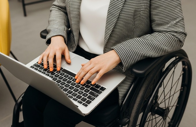Imagen de una persona en silla de ruedas utilizando un portátil