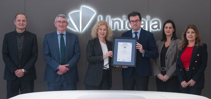 Imagen de Susana Pedrero, directora corporativa de personas y organización de Aenor, y Juan Medina, director general de personas, organización y legal de Unicaja, mostrando el certificado ISO 45001 que acaba de renovar la entidad financiera.