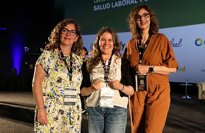 Marta Artieda (centro), directora de Recursos Humanos de Allianz Partners España, muestra el reconocimiento Top Wellbeing Company